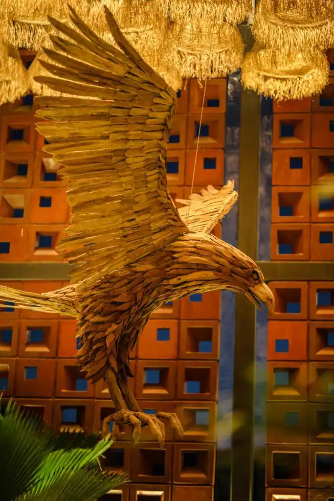 Photograph from Makau's own venue gallery: the double-height atrium, terracotta jaali and hanging raffia birds overhead.