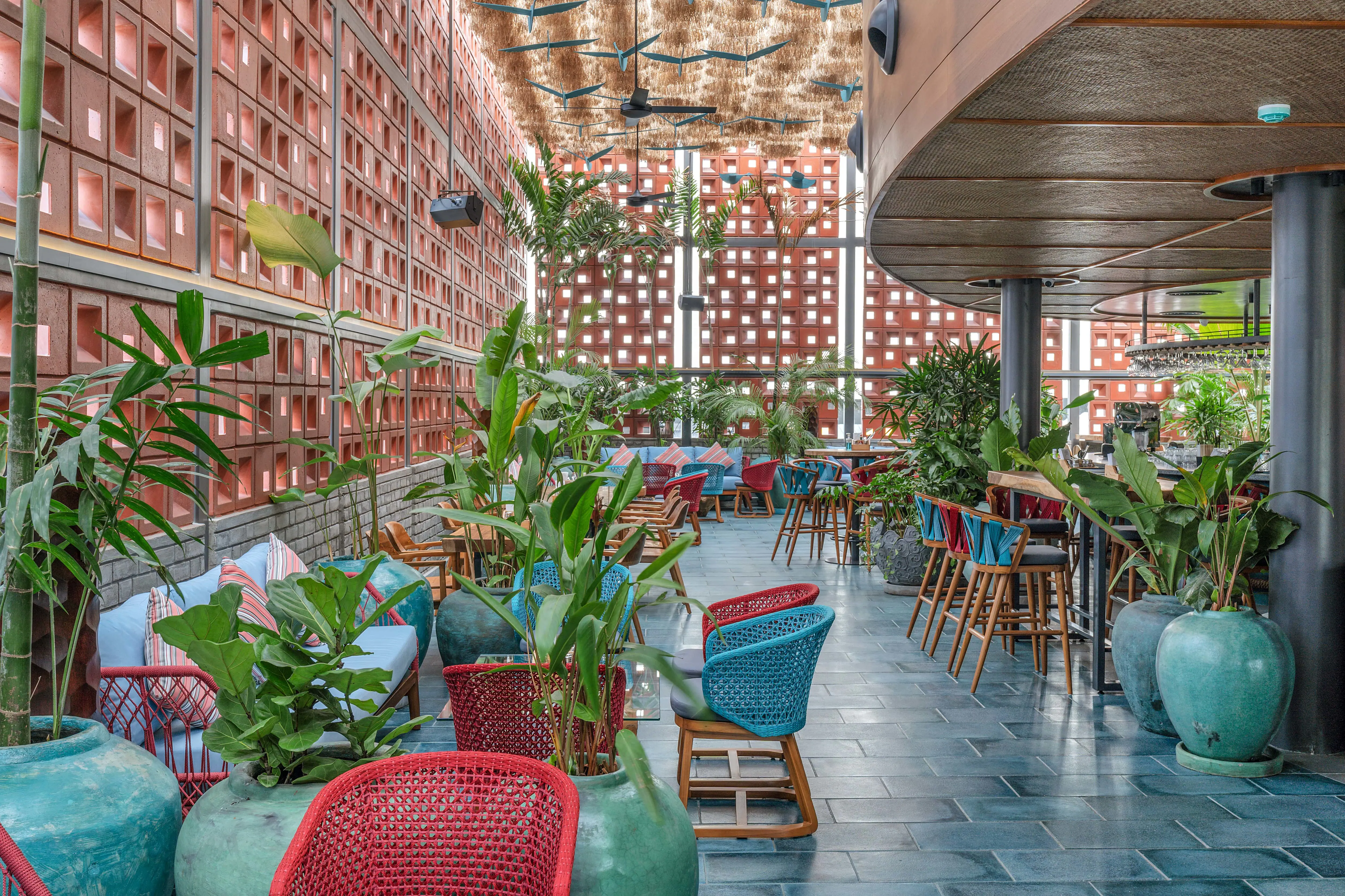 Photograph from Makau's own venue gallery: the double-height atrium, terracotta jaali and hanging raffia birds overhead.