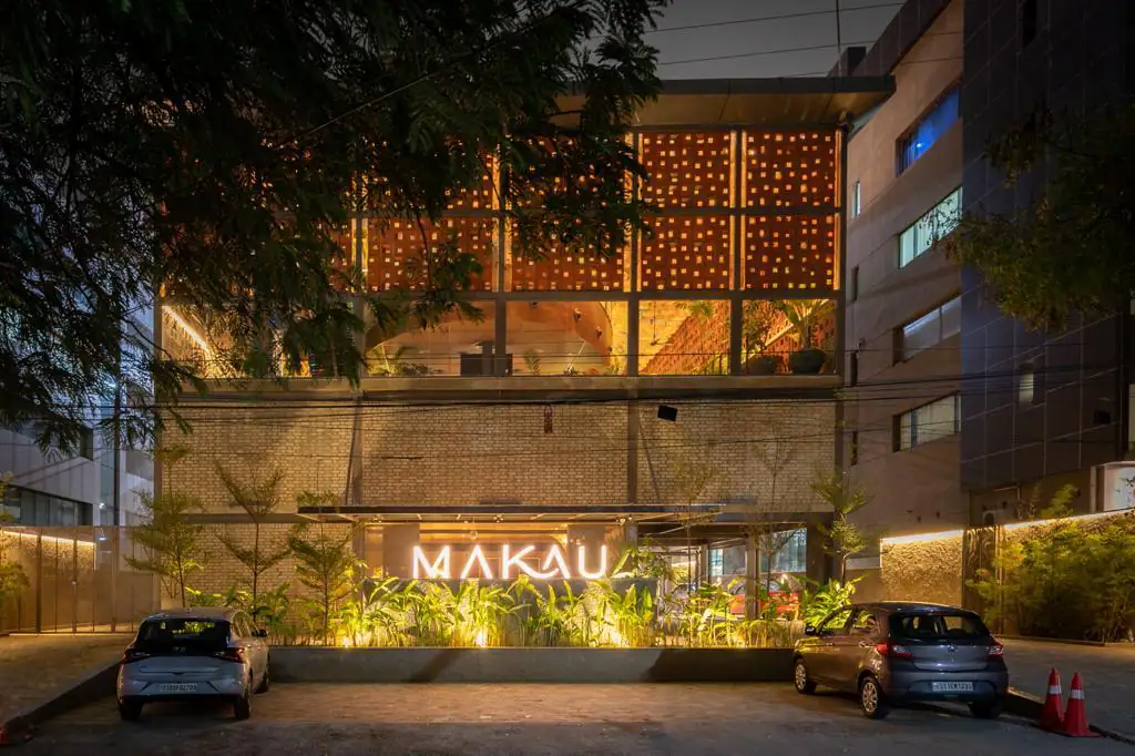 Photograph from Makau's own venue gallery: the double-height atrium, terracotta jaali and hanging raffia birds overhead.
