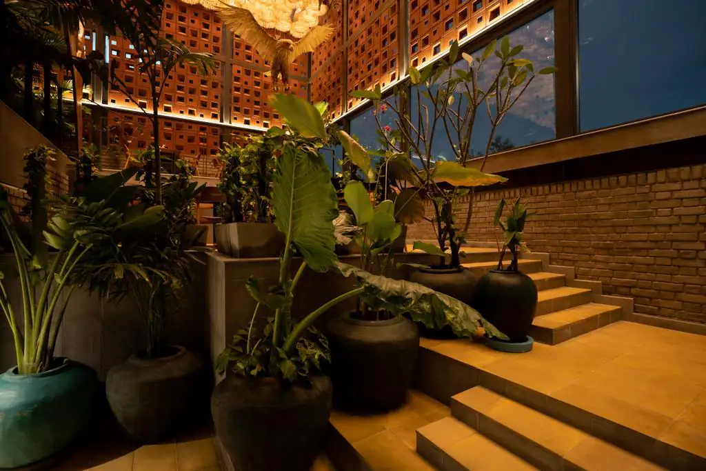Photograph from Makau's own venue gallery: the double-height atrium, terracotta jaali and hanging raffia birds overhead.