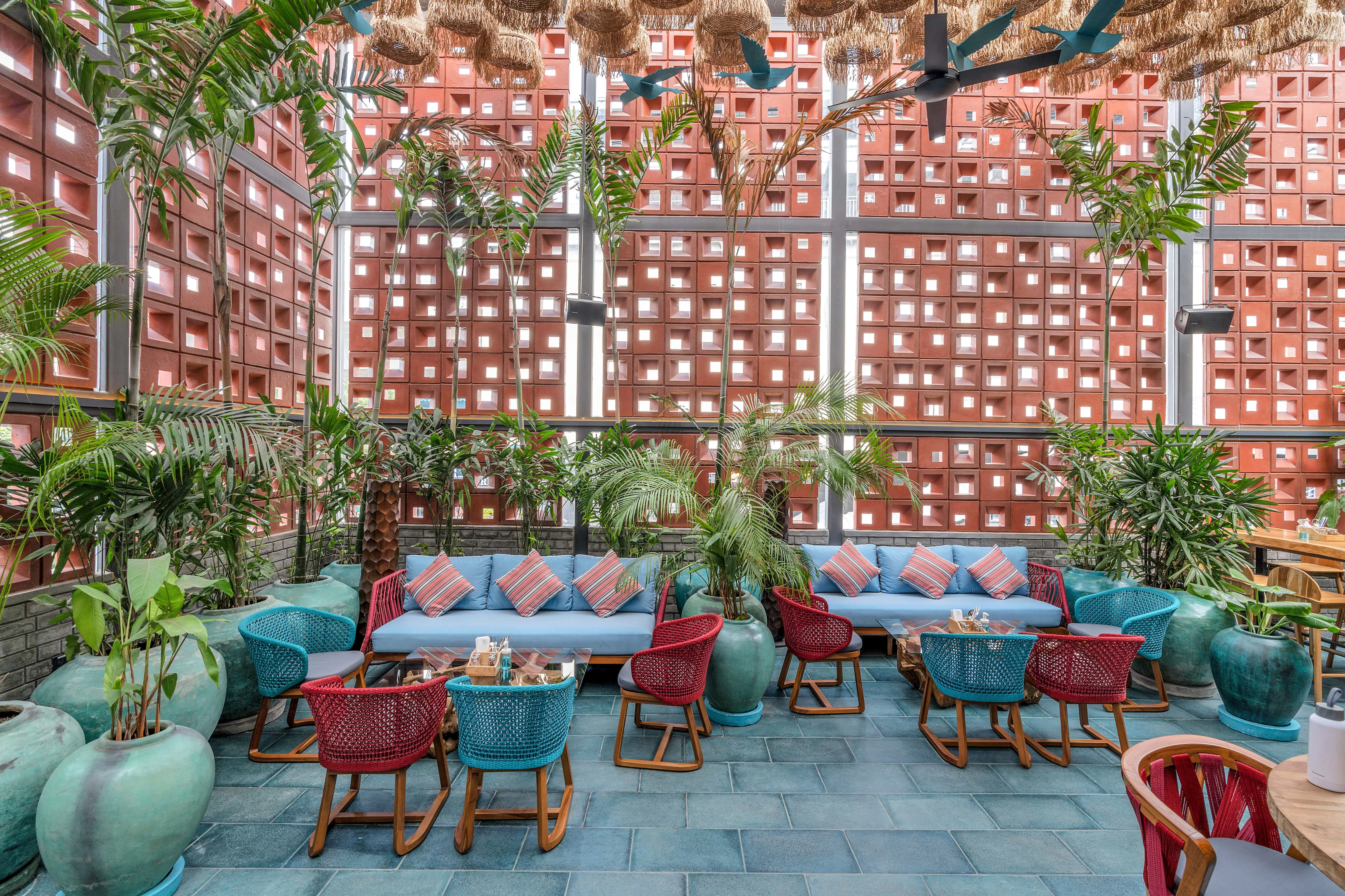 Photograph from Makau's own venue gallery: the double-height atrium, terracotta jaali and hanging raffia birds overhead.