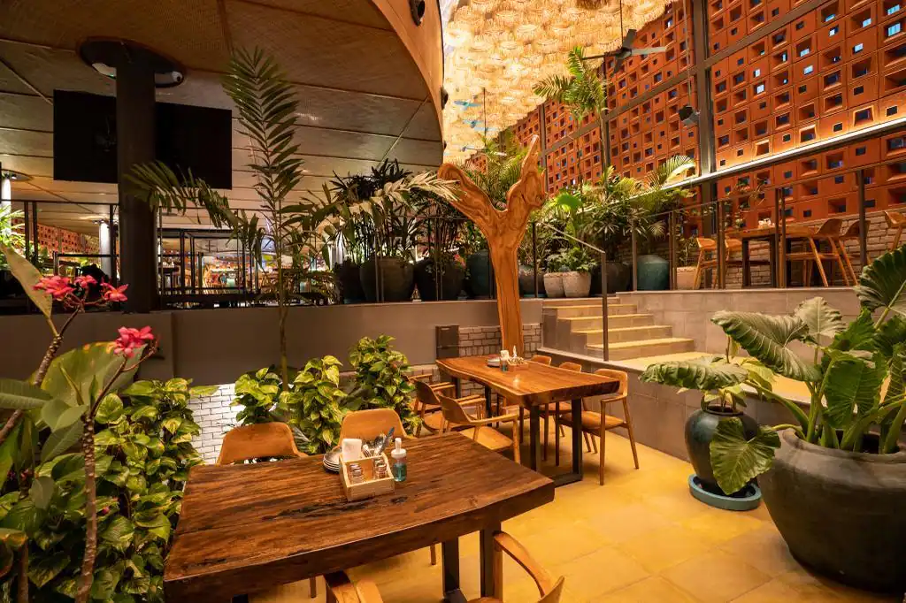 Photograph from Makau's own venue gallery: the double-height atrium, terracotta jaali and hanging raffia birds overhead.