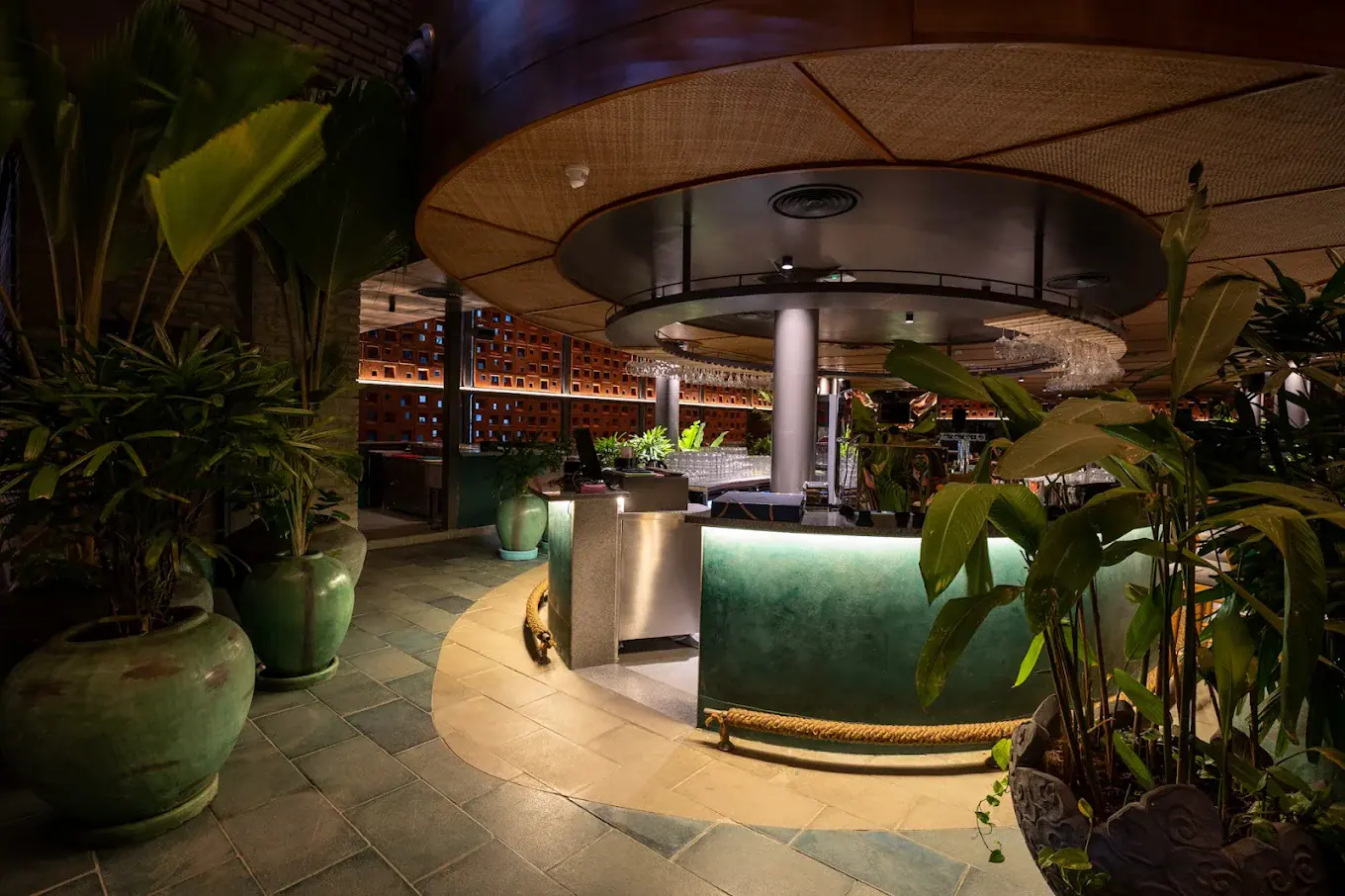 Photograph from Makau's own venue gallery: the double-height atrium, terracotta jaali and hanging raffia birds overhead.