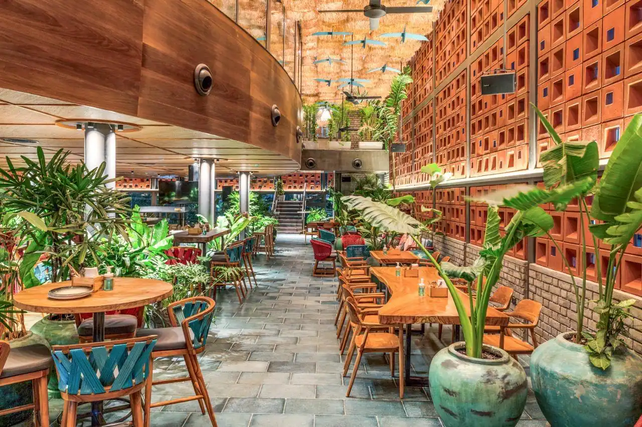 Photograph from Makau's own venue gallery: the double-height atrium, terracotta jaali and hanging raffia birds overhead.