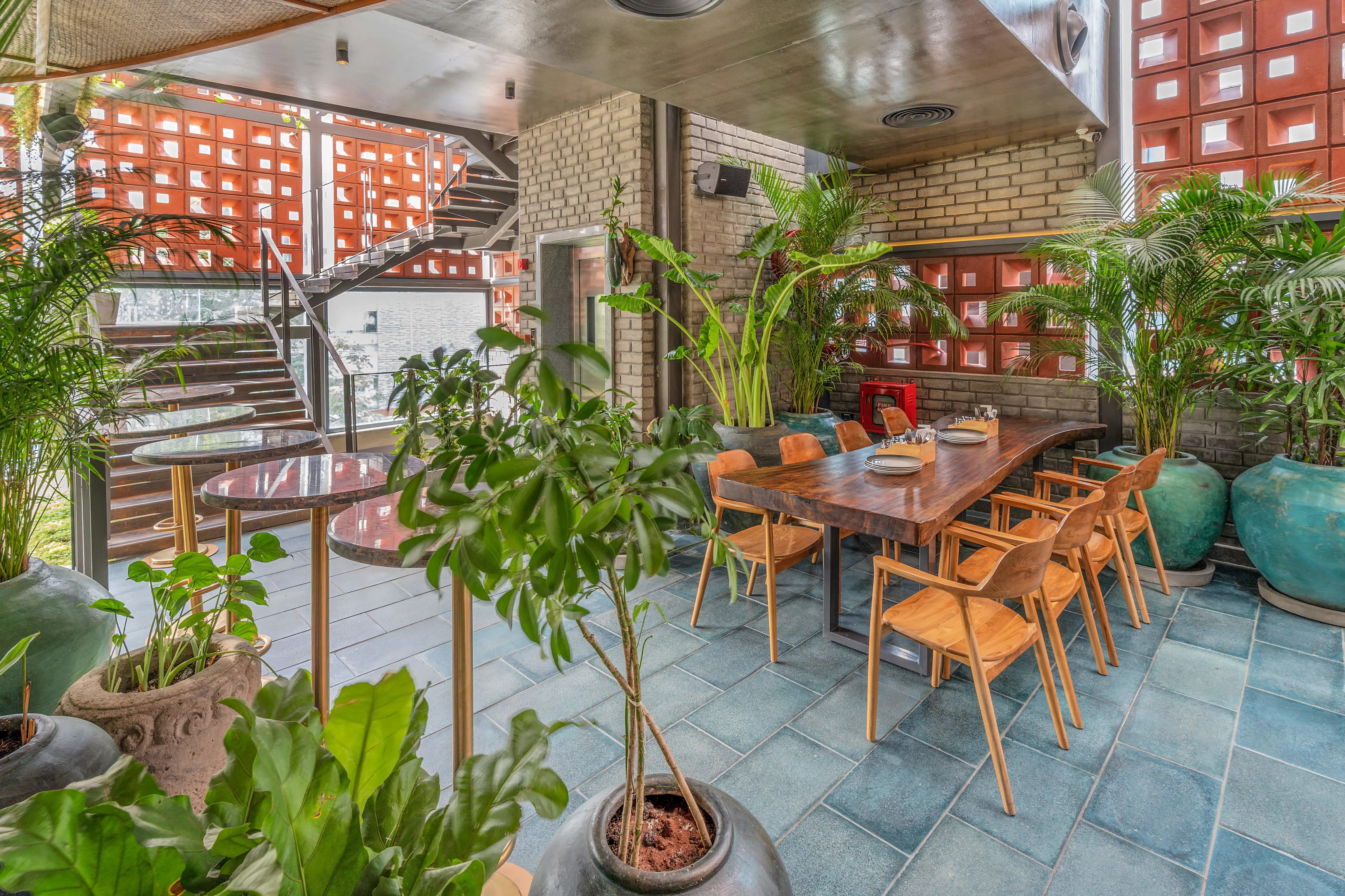 Photograph from Makau's own venue gallery: the double-height atrium, terracotta jaali and hanging raffia birds overhead.