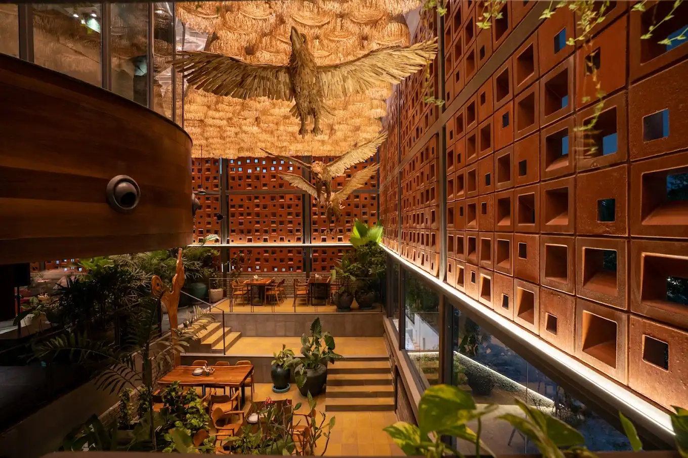 Photograph from Makau's own venue gallery: the double-height atrium, terracotta jaali and hanging raffia birds overhead.