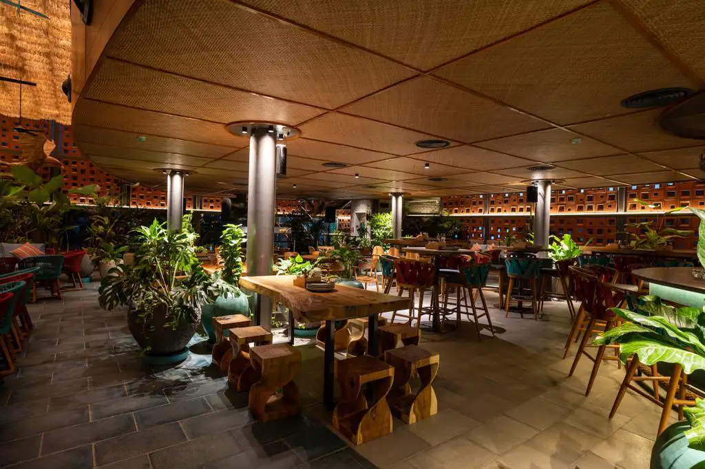 Photograph from Makau's own venue gallery: the double-height atrium, terracotta jaali and hanging raffia birds overhead.