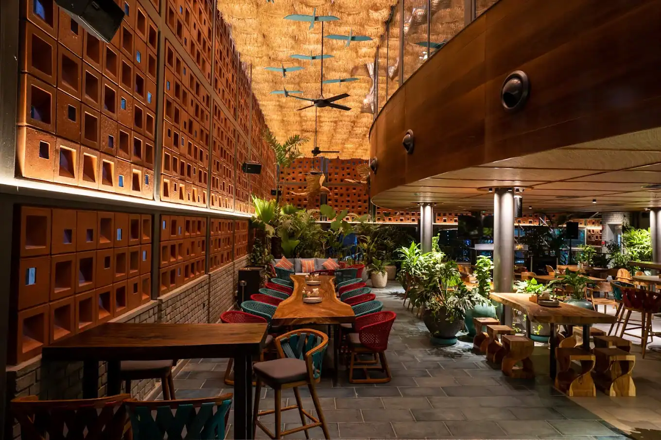 Photograph from Makau's own venue gallery: the double-height atrium, terracotta jaali and hanging raffia birds overhead.