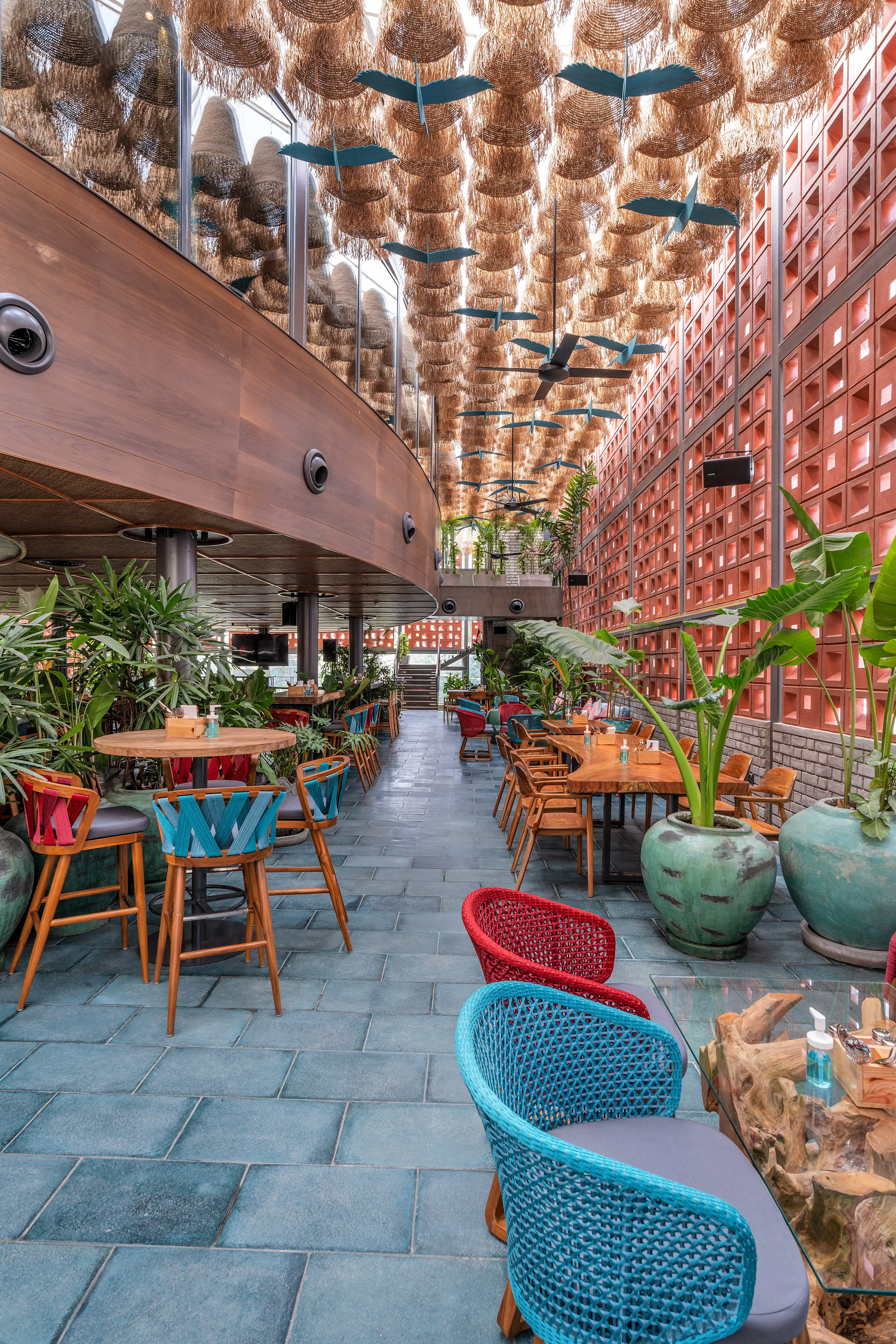 Photograph from Makau's own venue gallery: the double-height atrium, terracotta jaali and hanging raffia birds overhead.