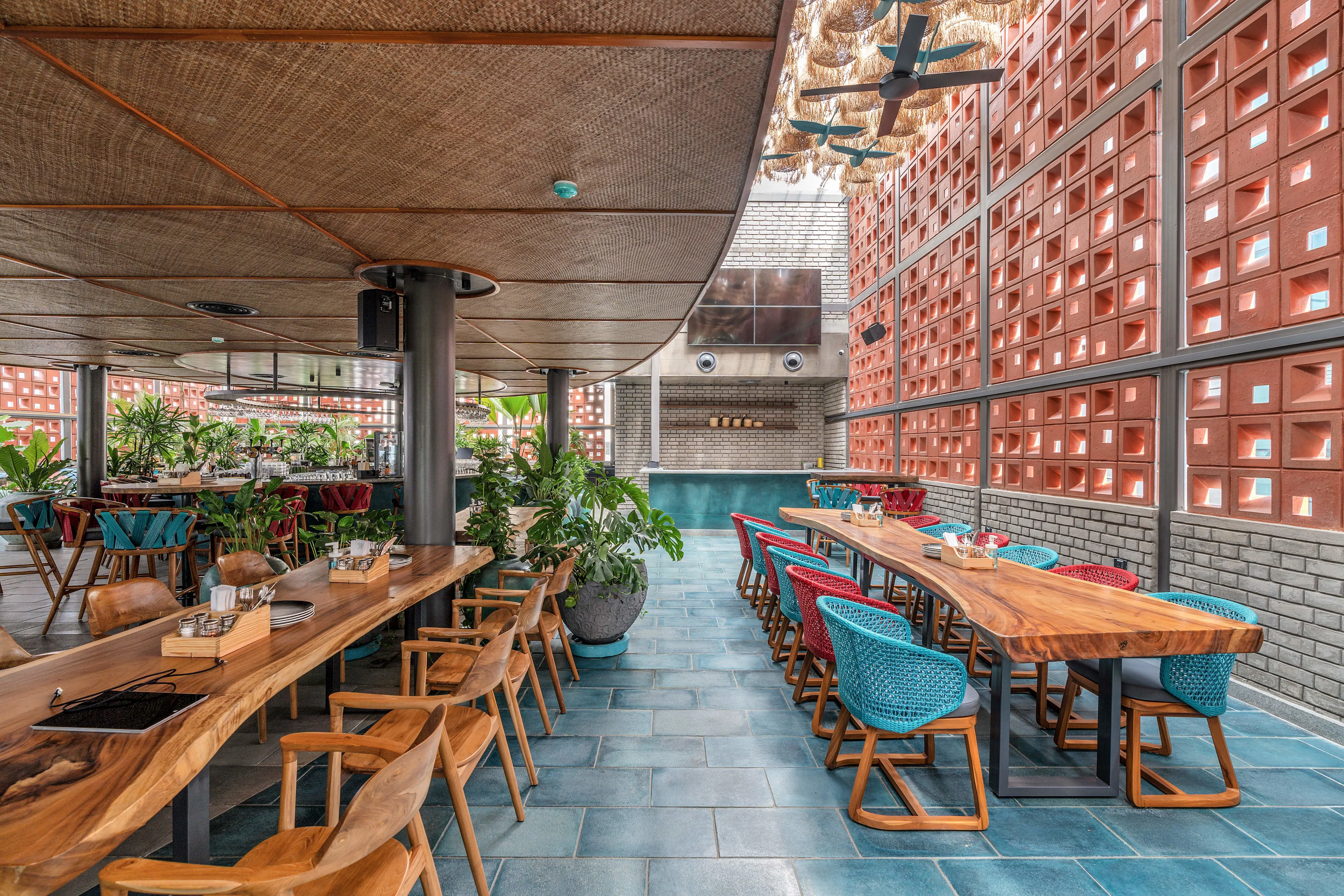 Photograph from Makau's own venue gallery: the double-height atrium, terracotta jaali and hanging raffia birds overhead.