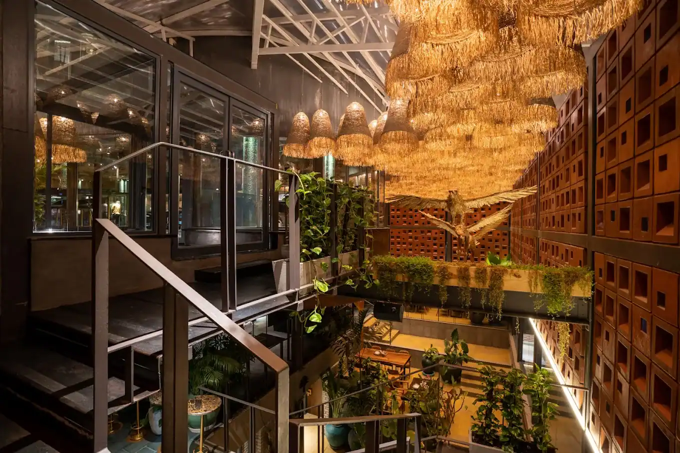 Photograph from Makau's own venue gallery: the double-height atrium, terracotta jaali and hanging raffia birds overhead.
