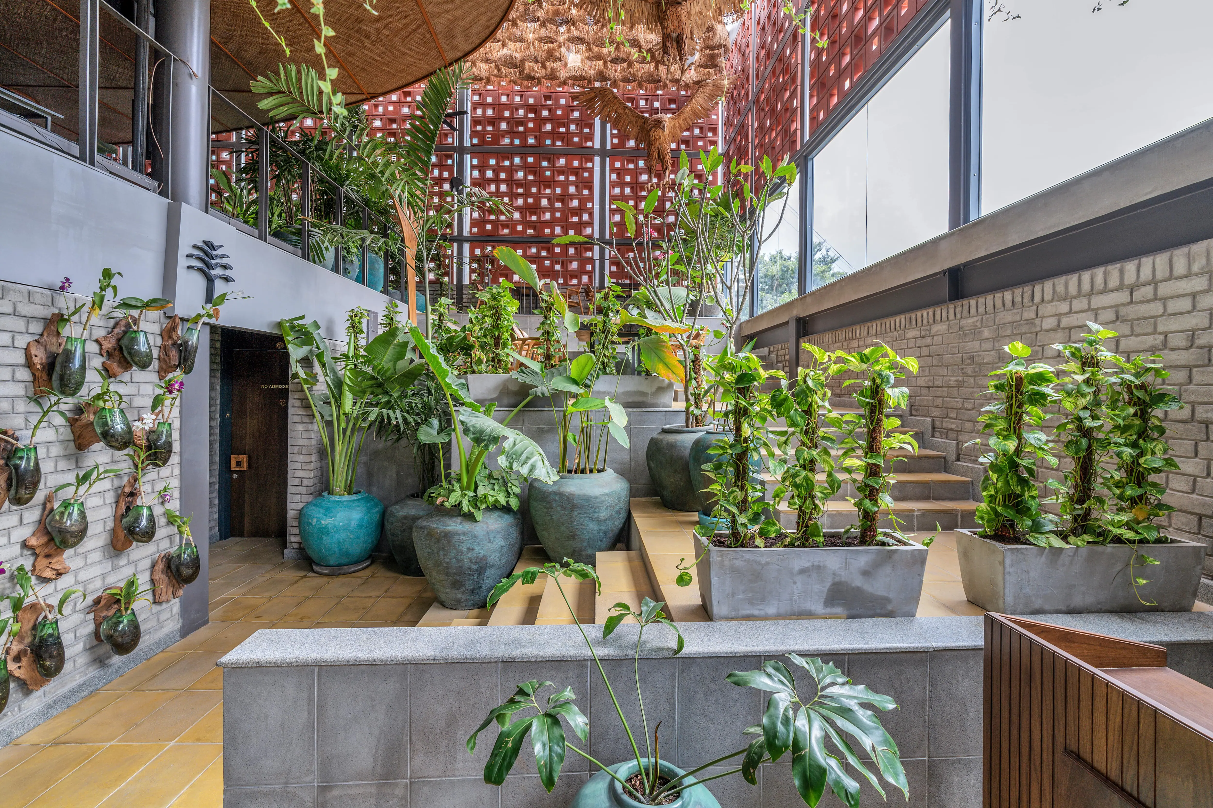 Photograph from Makau's own venue gallery: the double-height atrium, terracotta jaali and hanging raffia birds overhead.